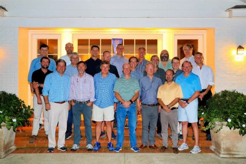 group of men posing in front of house