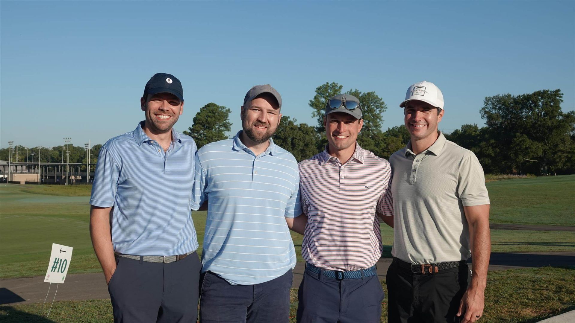 four men smiling in golf attire