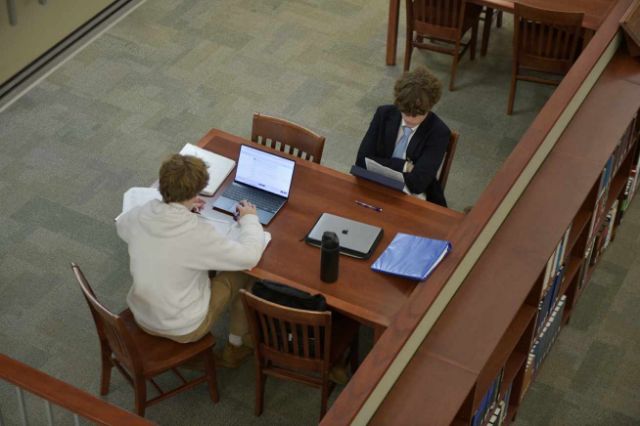 Two MUS students studying at a table in the library.
