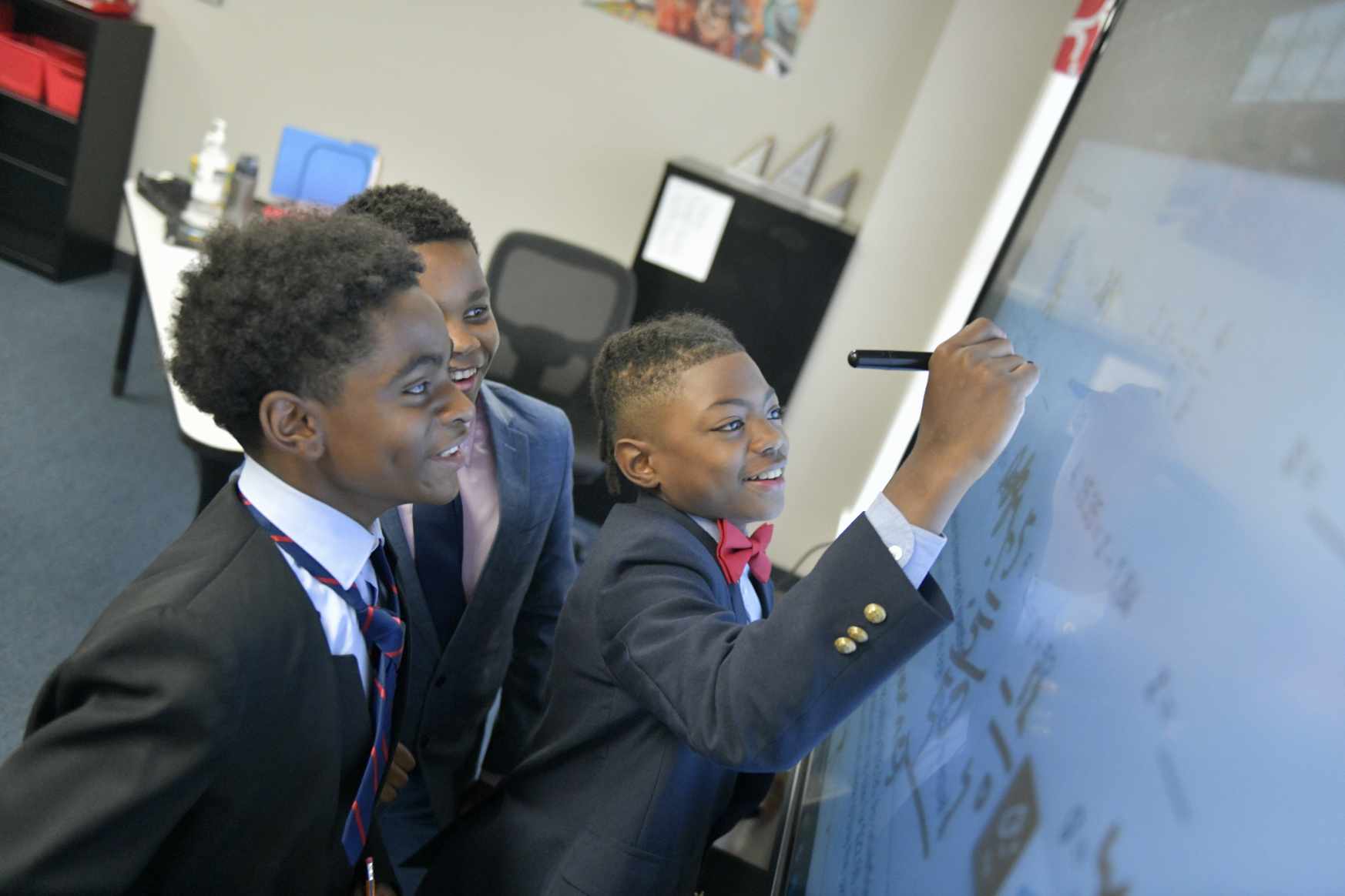 Group of students writing on a digital whiteboard.