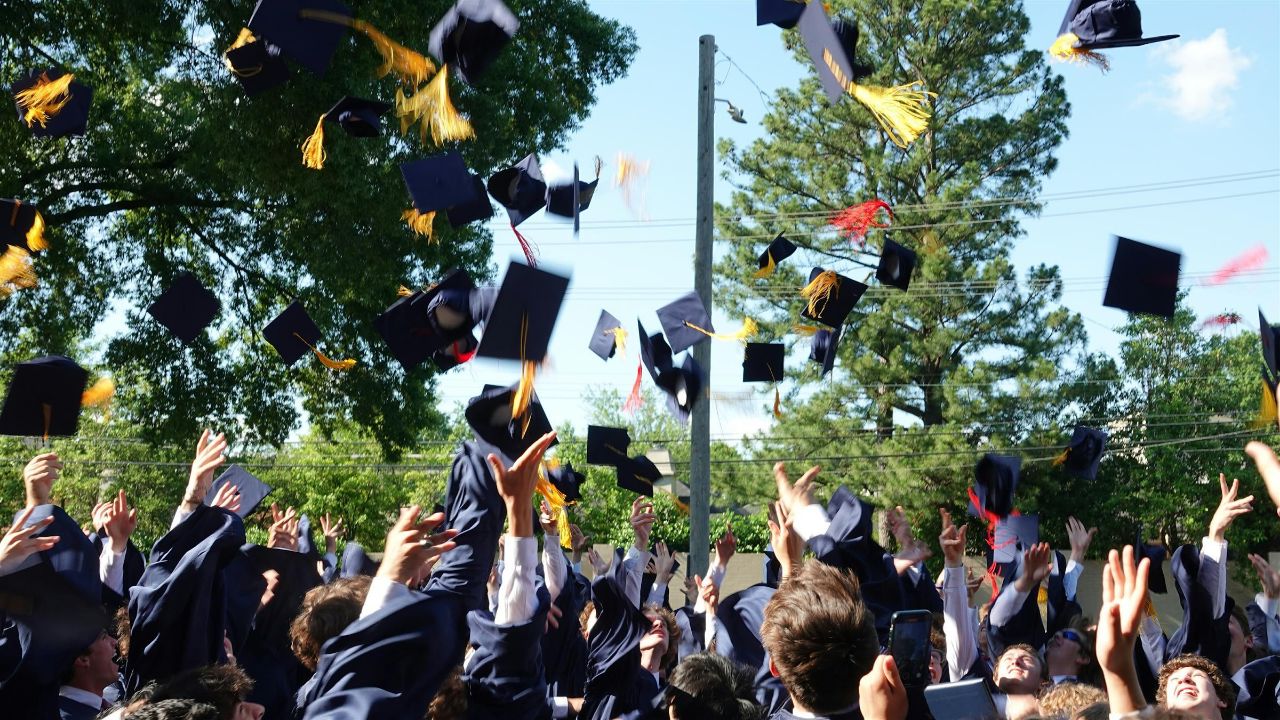 MUS students throwing their graduation caps in the air.